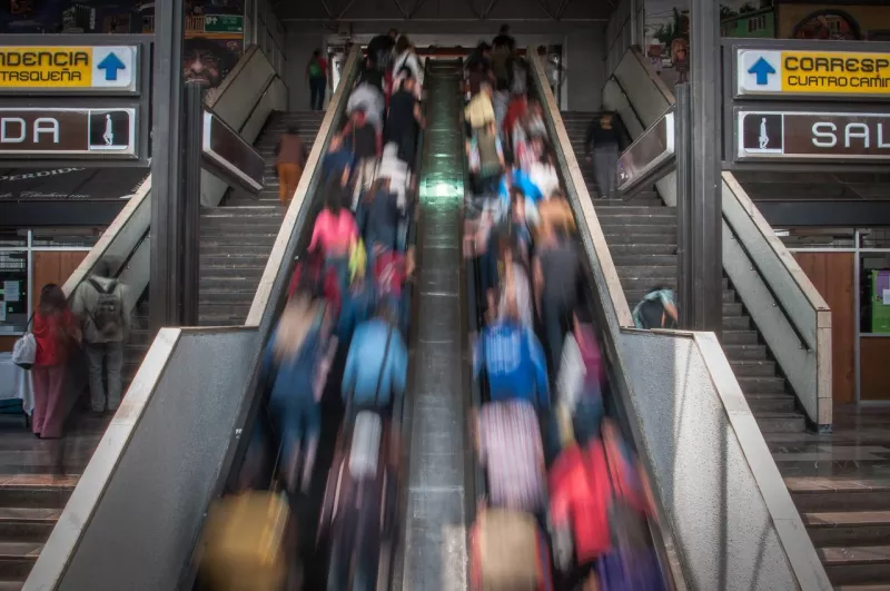 Personas suben por la escalera eléctrica del transbordo del metro Chabacano que conecta la línea café con la azul.Escaleras eléctricas-Metro.