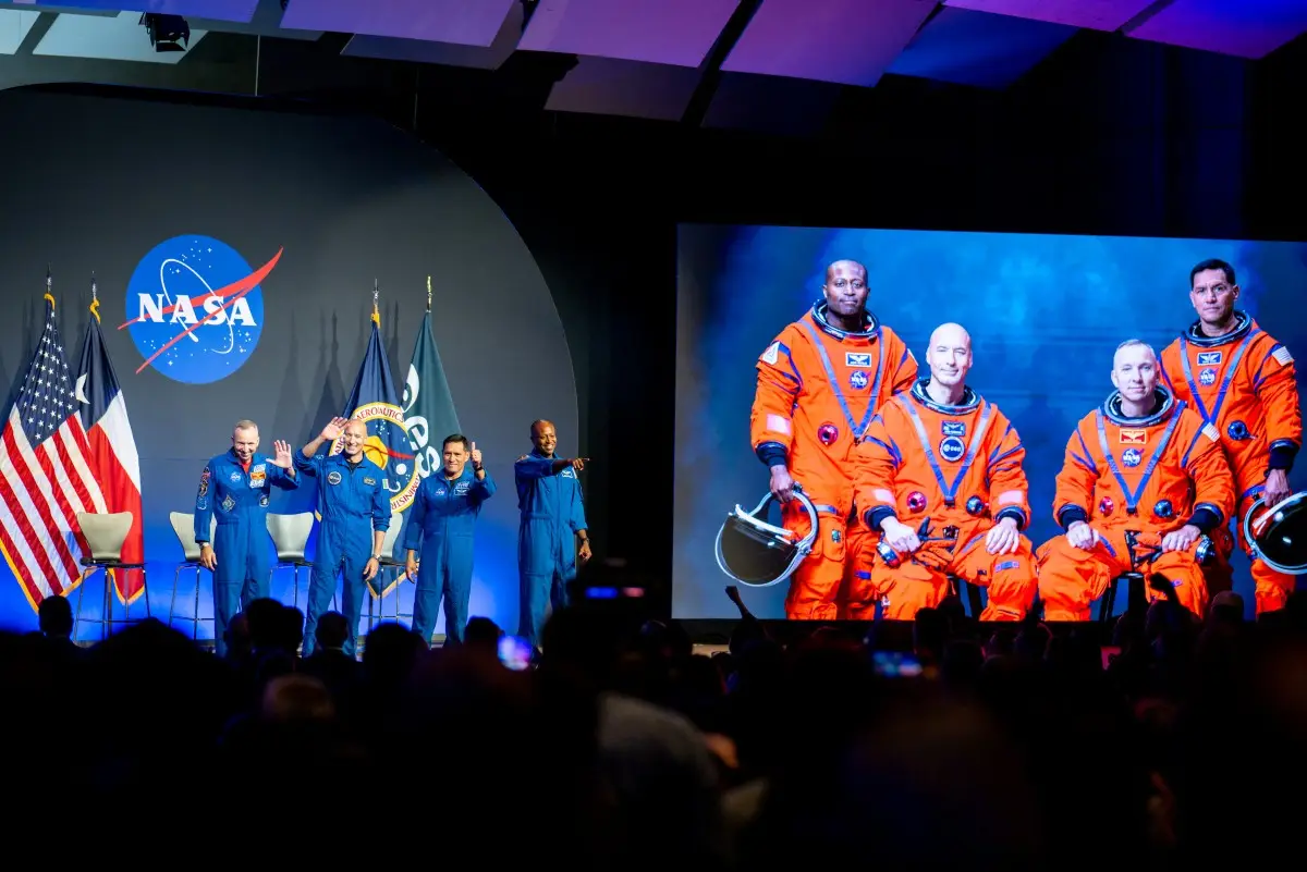 Los astronautas Randy Bresnik, Luca Parmitano de Italia y la Agencia Espacial Europea, Frank Rubio y Andre Douglas saludan a los miembros de la audiencia durante la conclusión de la revelación de la tripulación Artemis III en el Centro Espacial Johnson de la NASA el 9 de junio de 2026 en Houston, Texas. La NASA
