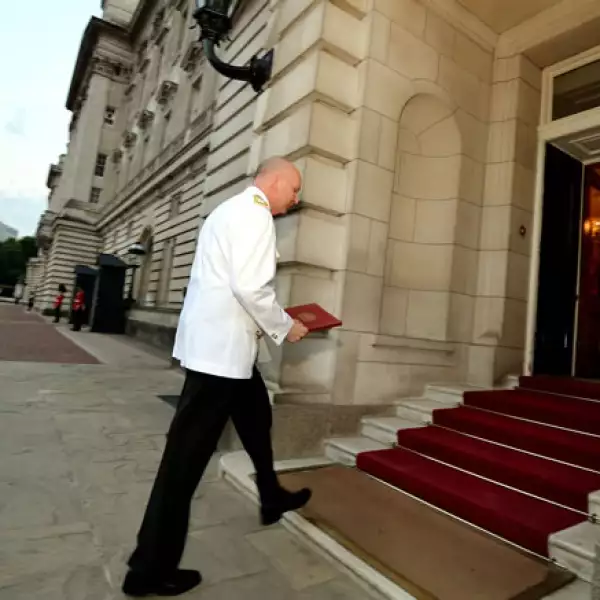 Philip Rhodes ingresa al Palacio de Buckingham con el anuncio en manos.
