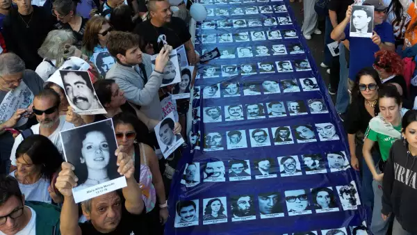 Vista aérea de manifestantes sosteniendo una pancarta con retratos de personas desaparecidas durante una marcha a la Plaza Mayo en el 50 aniversario del inicio de la última dictadura militar (1976-1983) en Buenos Aires el 24 de marzo de 2026.