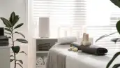 Herbal bags, towel and stones on couch in spa salon