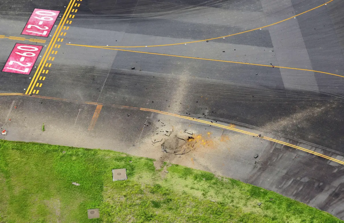 Una vista aérea tomada desde un helicóptero muestra un cráter de una explosión después de que una probable bomba de la Segunda Guerra Mundial explotara, en una calle de rodaje en el aeropuerto de Miyazaki en Miyazaki, suroeste de Japón, el 2 de octubre de 2024, en esta foto tomada por Kyodo
