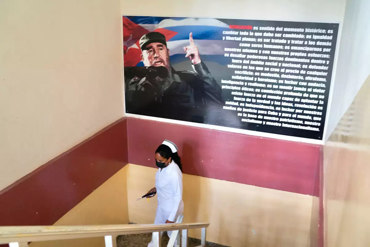 La enfermera, Yudmila Elia Castillo, de 45 años, muestra un mural de Fidel Castro en una clínica estatal, Policlinico Docente 5 de Septiembre, en Playa, el municipio más septentrional de La Habana, Cuba, el 19 de abril de 2022.
