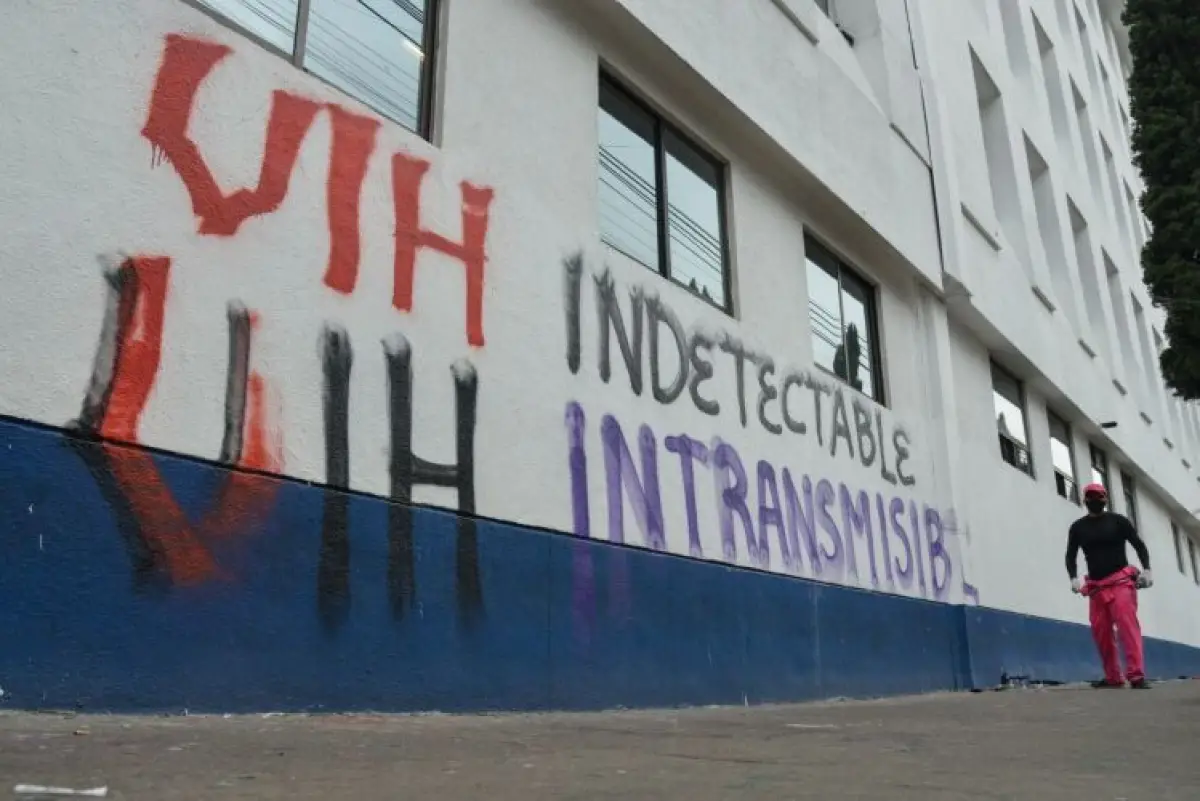 En la imagen se oberva una pared pintada con la leyenda: "VIH indetectable. VIH intransmisible". 