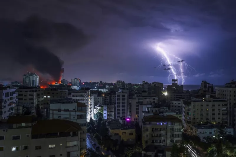 Los rayos caen mientras el humo se balancea después de un ataque aéreo israelí en la ciudad de Gaza el 9 de octubre de 2023.