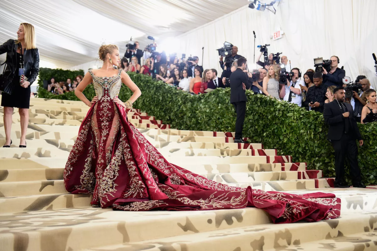 Blake Lively en la Met Gala del 2018 con un vestido brocado rojo y dorado. 