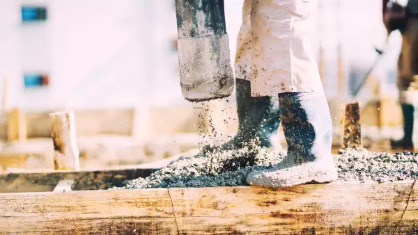 Constuction details - worker laying cement or concrete with automatic pump"n