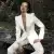 Una modelo sentada luce un conjunto color blanco de pantalón y saco de DHIERRO, marca exclusiva de El Palacio de Hierro