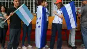Una mujer con una bandera hondureña hace cola para votar durante las elecciones generales en Tegucigalpa, Honduras, el 30 de noviembre de 2025.