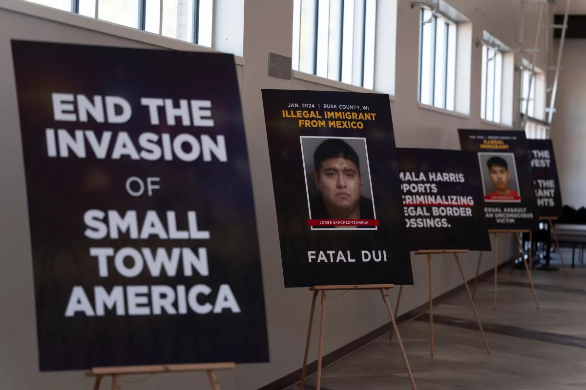Carteles que condenan a los inmigrantes acusados de delitos forman una pared el día de un evento de campaña para el candidato presidencial republicano y ex presidente de los Estados Unidos Donald Trump en el Prairie du Chien Area Arts Center en Prairie du Chien, Wisconsin, EE. UU. 28 de septiembre de 2024. (Imagen principal del artículo '¿En qué consisten las propuestas migratorias de Trump y Kamala Harris?')