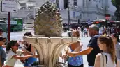 Los miembros del publc llenan las botellas con agua en una fuente de Roma, el 14 de julio de 2023, mientras Italia se ve afectada por una ola de calor.