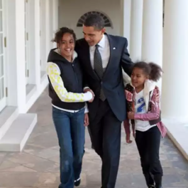 Barack y sus hijas, Malia y Sasha, caminando por la Colonnade.