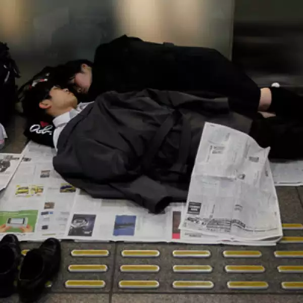 Varias personas duermen en el Tokio International Forum, un centro de espectáculos adaptado como un refugio temporal.