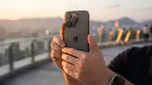 Hombre sostiene el iPhone 15 Pro para tomar una foto del atardecer.
