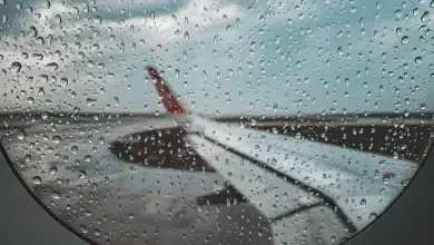 Vista del ala lateral de un avión desde dentro con la ventanilla con poca visibilidad tras el paso de lluvia.