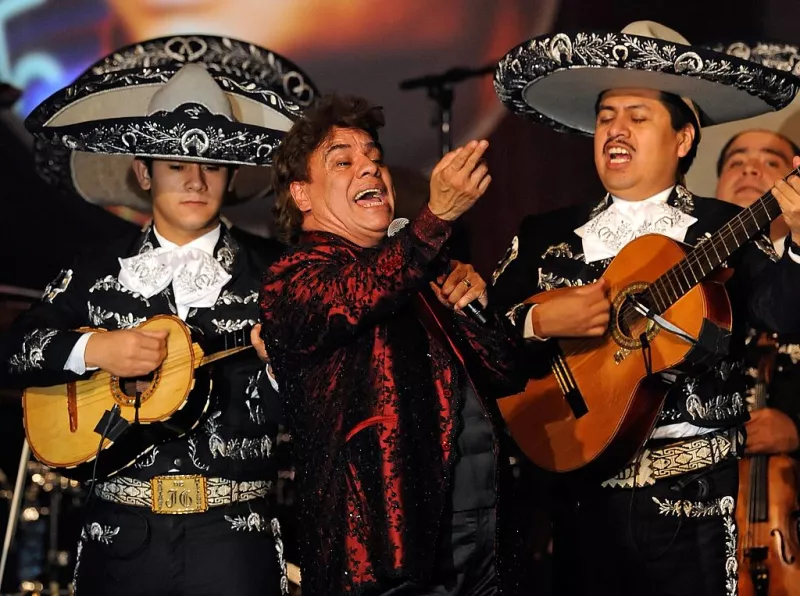 Foto de Juan Gabriel en 2009, cantando con mariachi detrás de él, durante un concierto en su honor al ser nombrado Persona del Año.