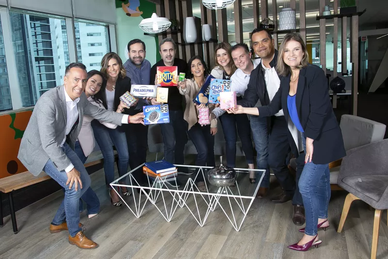 Equipo diverso de Mondelēz México: mujeres y hombres de diferentes edades en una sala de trabajo.