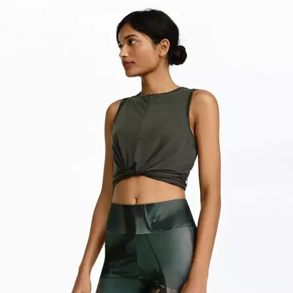 Una playera sin mangas en verde seco (básico) que combine con el estampado de tus leggins, muestra ese six pack, con el detalle del top que aparenta un nudo adelante. 
Oysho.com / Top: $449, leggins: $799