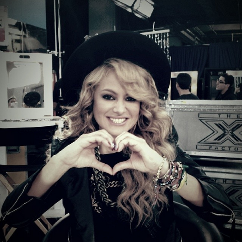 Con un heartsign, es como saluda la chica dorada.
