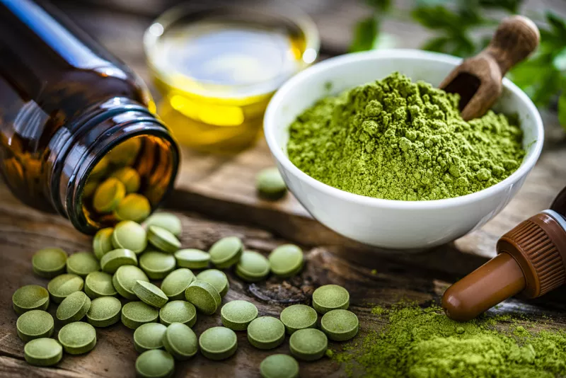 Moringa oleifera powder and pills on rustic table