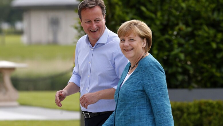 David Cameron –izq- da la bienvenida a la canciller alemana Angela Merkel para la reunión, donde también comenzaron las negociaciones para un tratado de libre comercio entre Europa y EU.
