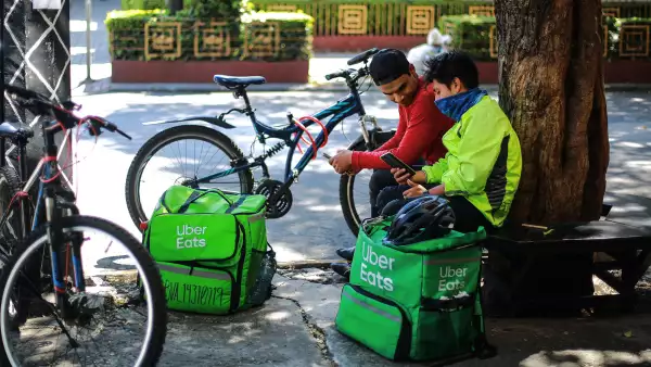 (Repartidores de Uber Eats, descansan antes de tomar otra orden de trabajo)