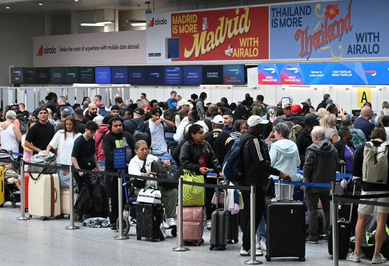 Unos pasajeros aguardan con su equipaje mientras hacen cola para facturar en la Terminal Sur del aeropuerto de Londres-Gatwick, cerca de Crawley (sur de Inglaterra), el 9 de septiembre de 2026, tras una segunda jornada de graves perturbaciones causadas por un problema en los sistemas de control de tráfico aéreo de NATS.