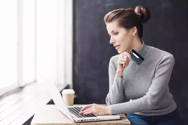 Mujer consultando movimientos de su tarjeta de crédito empresarial Konfío, en su laptop.