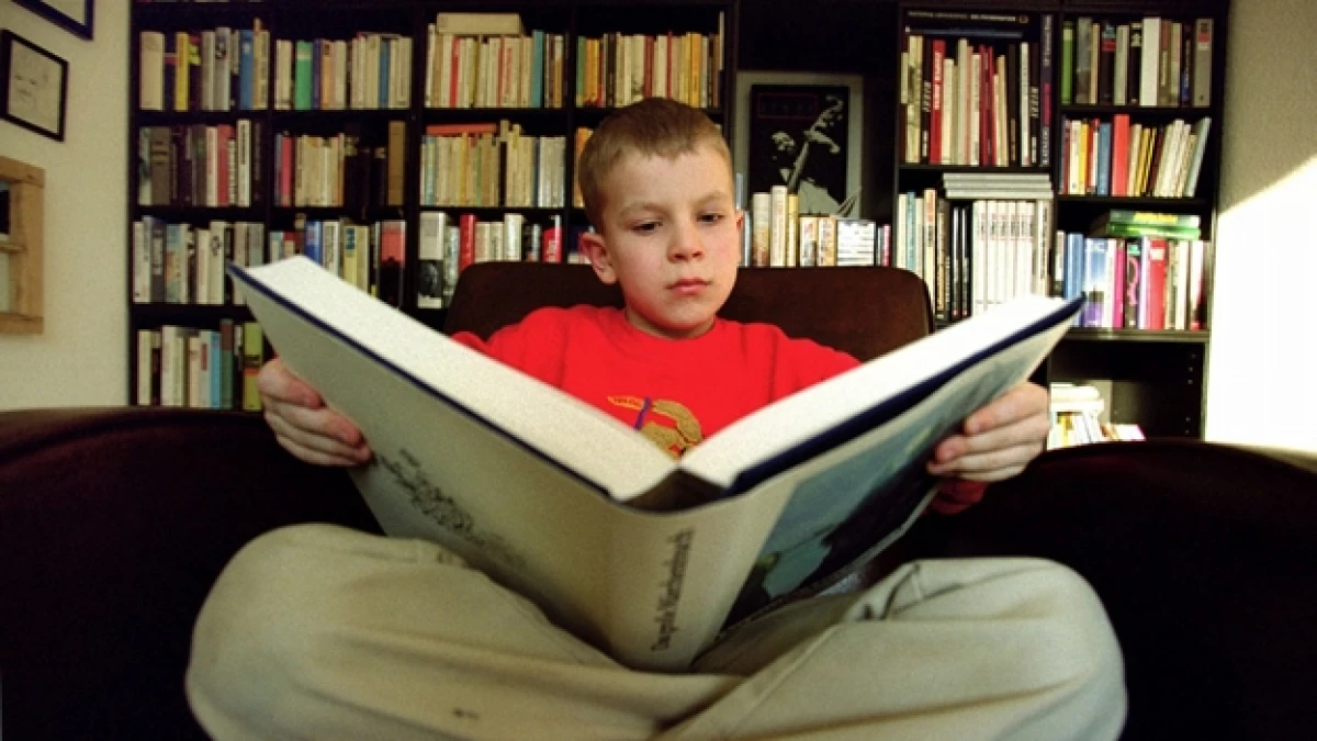 Un menor de edad con problemas de aprendizaje por dislexia trabaja para solucionar su problema, leyendo