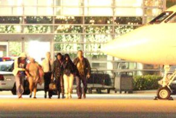 Rihanna (de pantalón blanco) viajó en el mismo avión que Chris Brown.