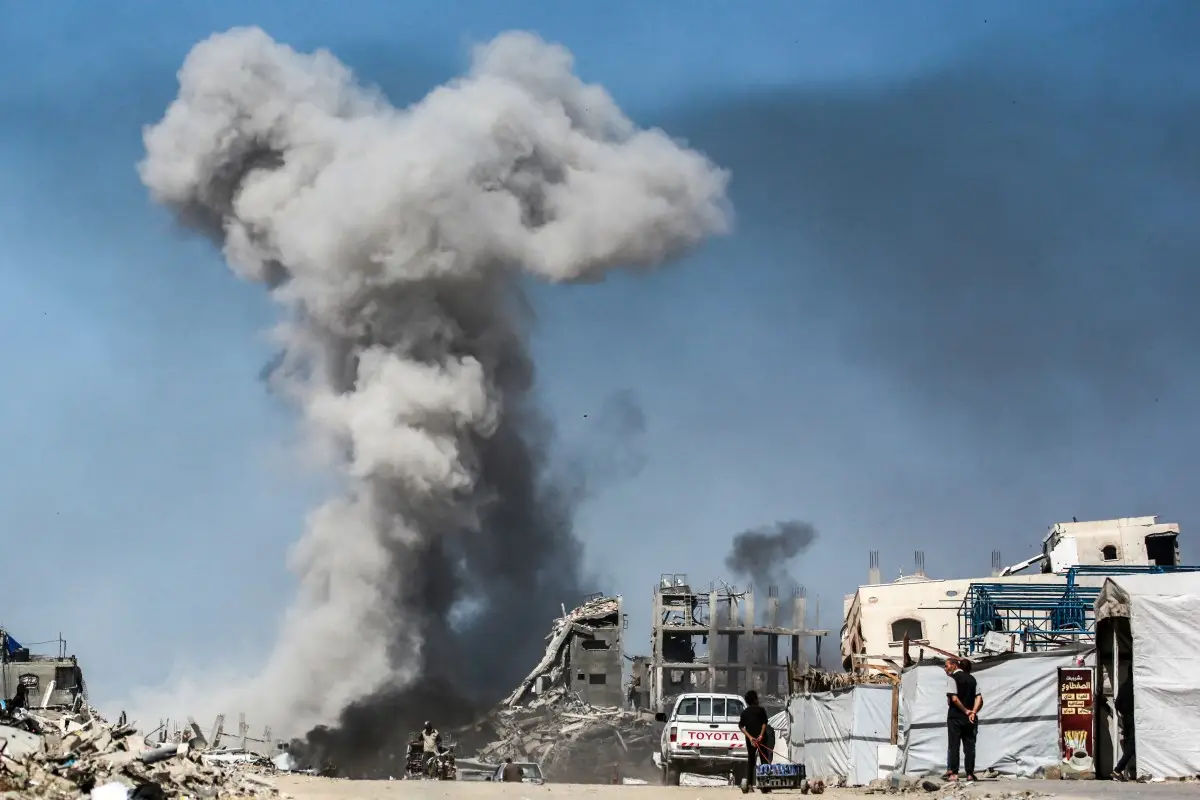 La gente observa cómo se esfuma después de un ataque israelí en Jabalia, en el norte de la Franja de Gaza, el 25 de mayo de 2025. Los rescatistas en Gaza dijeron que 22 personas murieron y docenas más resultaron heridas en ataques aéreos israelíes en todo el territorio palestino el 25 de mayo.
