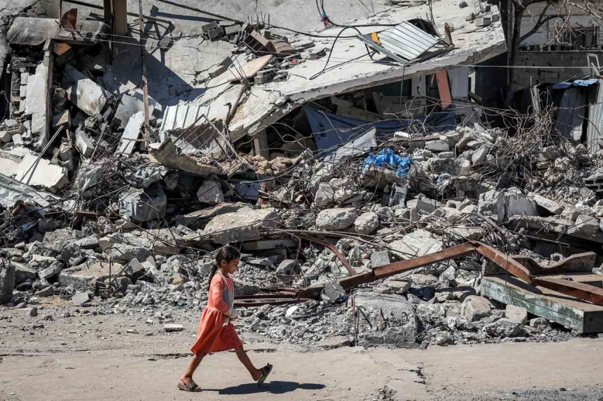 Una niña pasa entre los escombros de un edificio derrumbado en Rafah, en el sur de la Franja de Gaza, el 9 de abril de 2024, en medio del conflicto en curso en el territorio palestino entre Israel y el grupo militante Hamas.