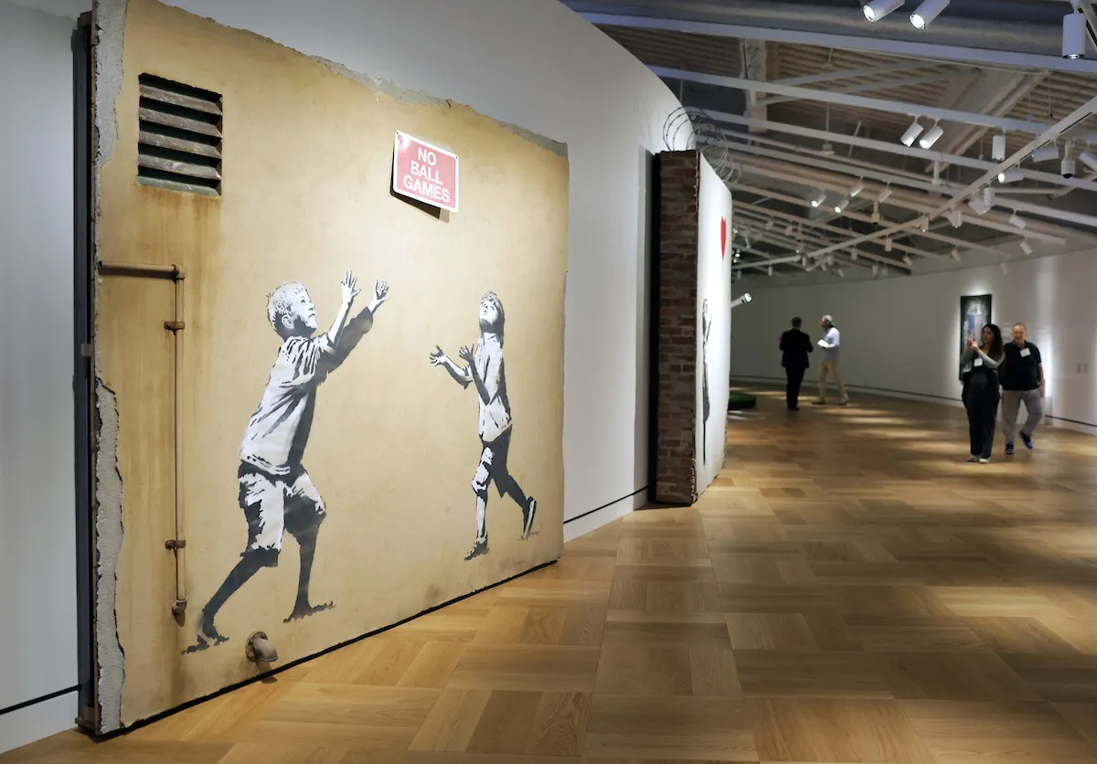 Unos visitantes recorren obras creadas por Banksy en el nuevo Lucas Museum of Narrative Art.