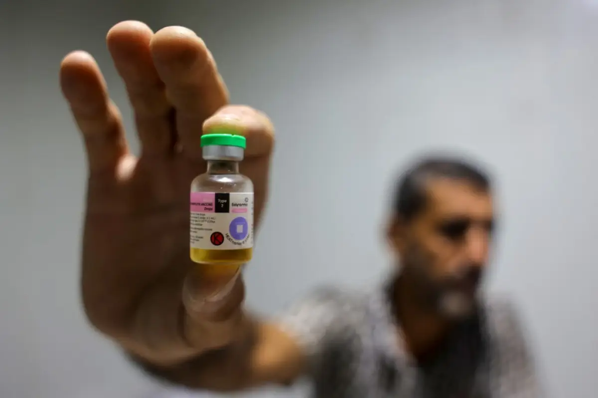Un trabajador muestra un frasco que contiene una vacuna contra la polio proporcionada con el apoyo de UNICEF a la Franja de Gaza a través del cruce de Karm Abu Salem, también conocido como Kerem Shalom, en un depósito perteneciente al Ministerio de Salud de Gaza el 25 de agosto de 2024, en medio del conflicto en curso en el territorio palestino entre Israel y el grupo militante palestino Hamas. (Imagen principal del artículo 'Vacunación en tiempos de guerra: cómo proteger vidas bajo los bombardeos en Gaza')
