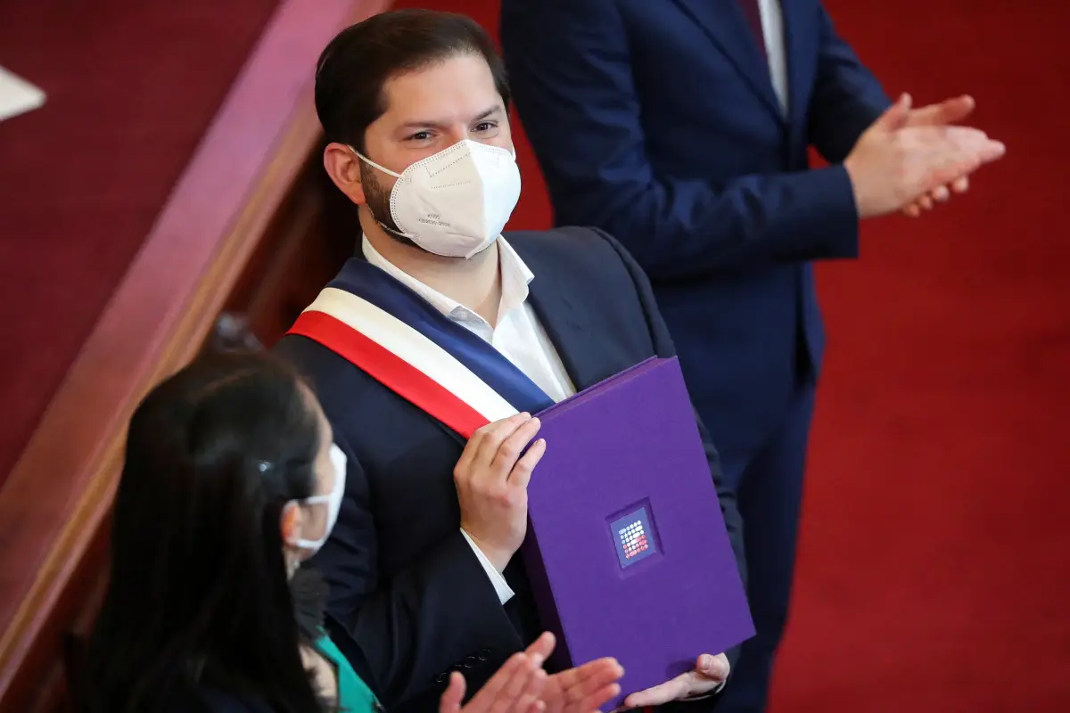El presidente de Chile, Gabriel Boric, posa con el borrador final de la nueva constitución, antes de un referendo nacional el 4 de septiembre, cuando ciuddanos aprobarán o rechazarán el proyecto. 