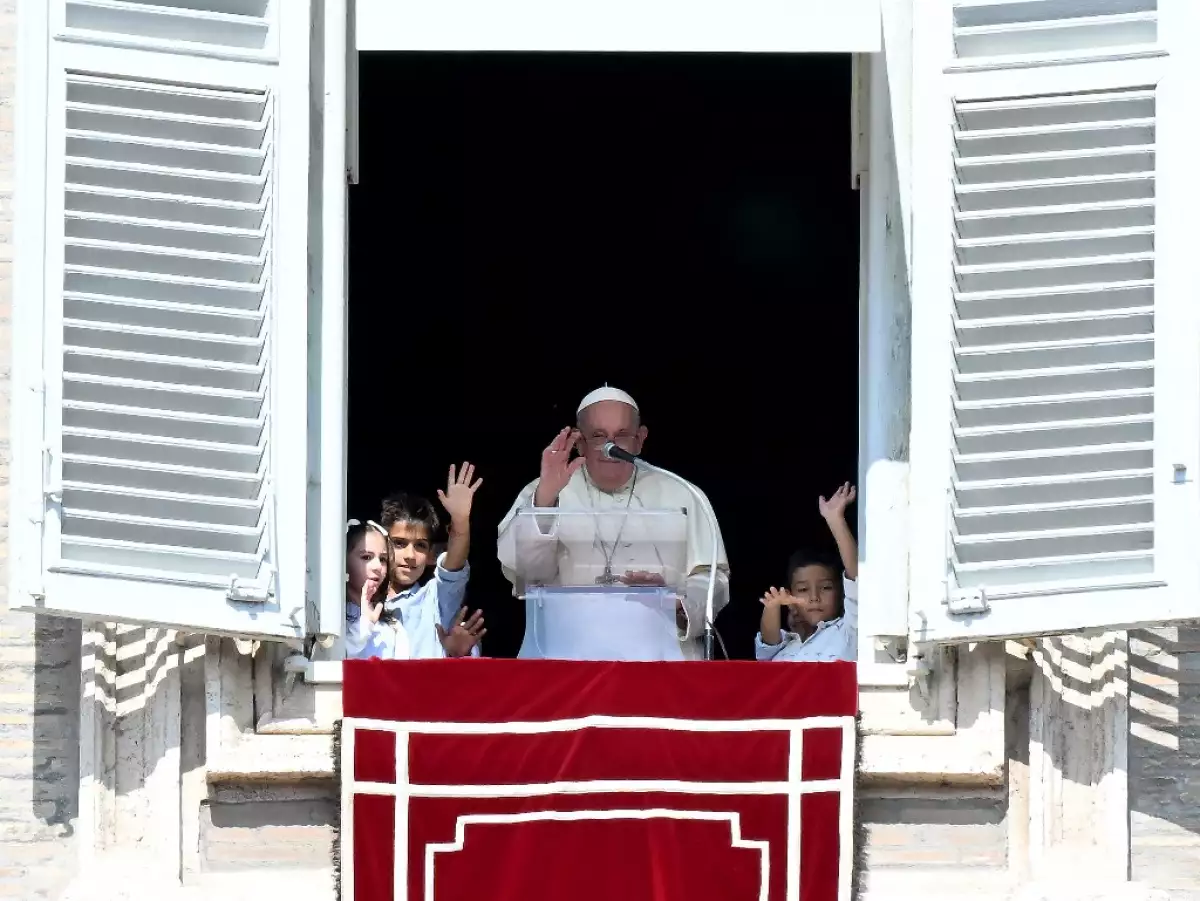 El Papa Francisco saluda a los peregrinos flanqueados por niños de los cinco continentes durante la oración dominical de Ángelus en la Plaza de San Pedro en el Vaticano el 1 de octubre de 2023.