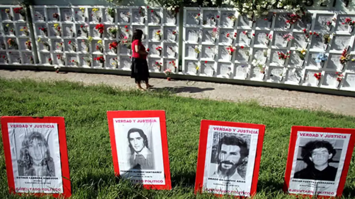 mujer camina entre tumbas de victimas de ditadura de augusto pinochet