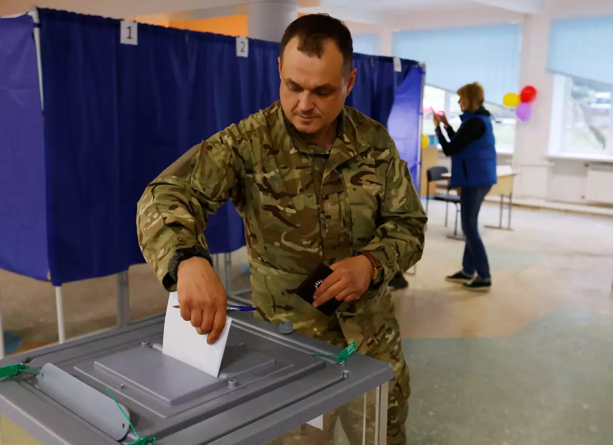 Un hombre vestido de militar vota