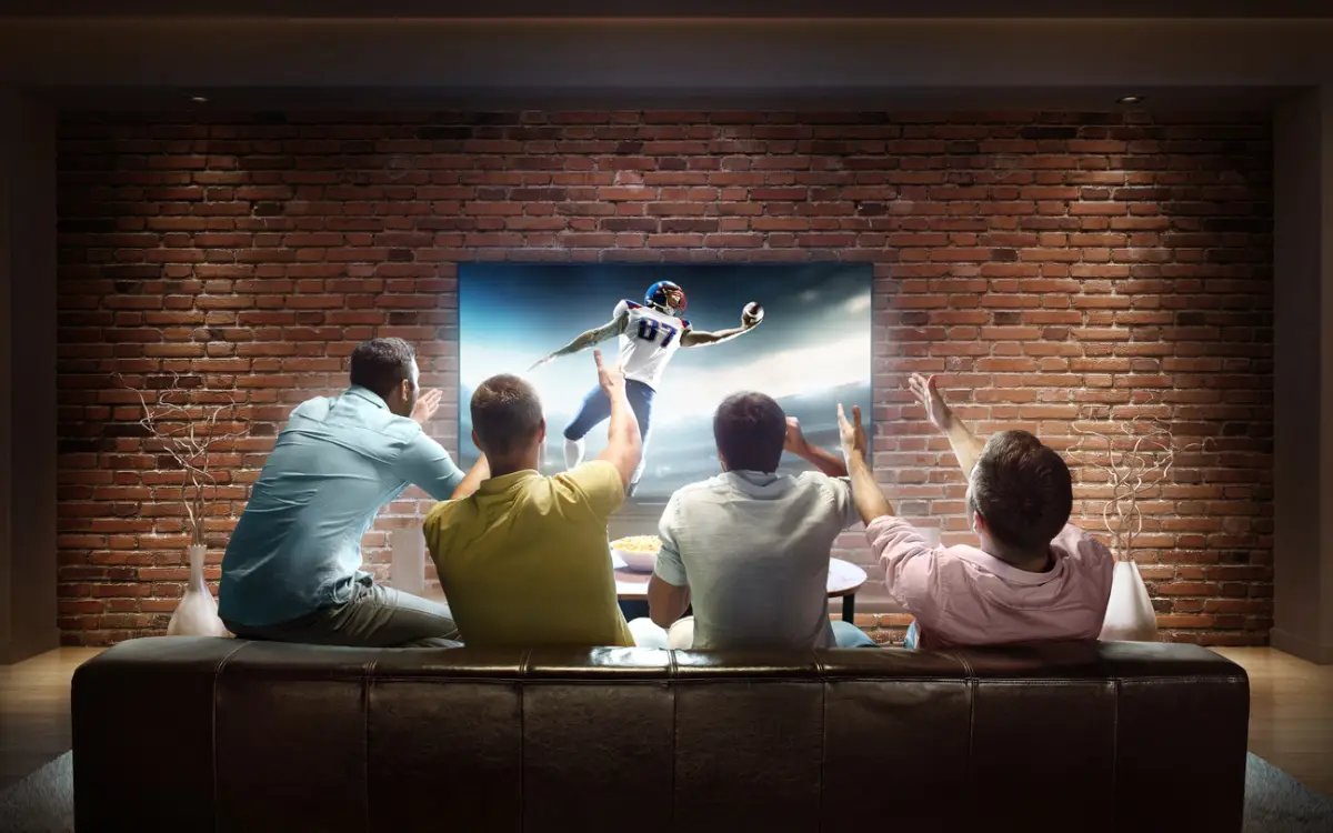 Star Plus precio en México (cuatro personas miran emocionados un programa de televisión)