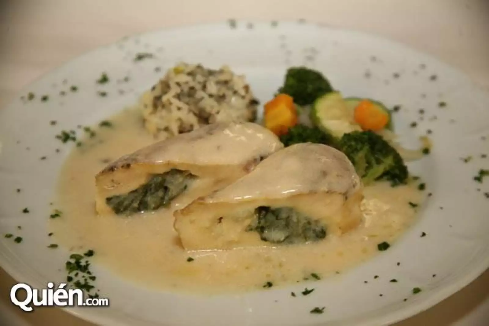 Pechuga de pollo rellena de espinacas en salsa de queso con guarnición de arroz pilar y vegetales a la mantequilla