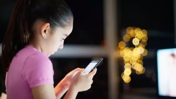 Una niña ve su smartphone con preocupación