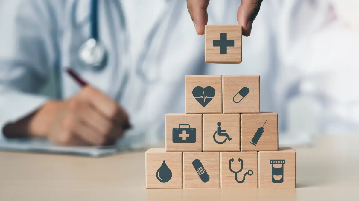 Concepto de seguro médico para su salud donde una mano sostiene un bloque de madera con icono de atención médica