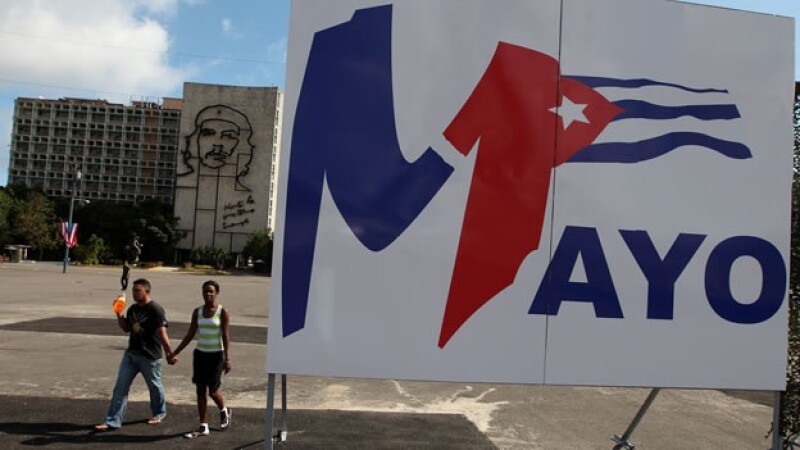 cubanos pasean ante un bandera
