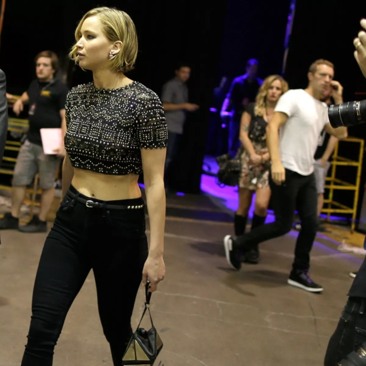 Lawrence fue captada muy guapa en backstage del IHeartRadio. Atrás se puede apreciar al cantante británico yendo en otra dirección.