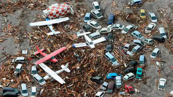 Casas y aviones son llevados por la corriente del tsunami, a pocos kilómetros del aeropuerto de Sendai, al noreste de Japón.