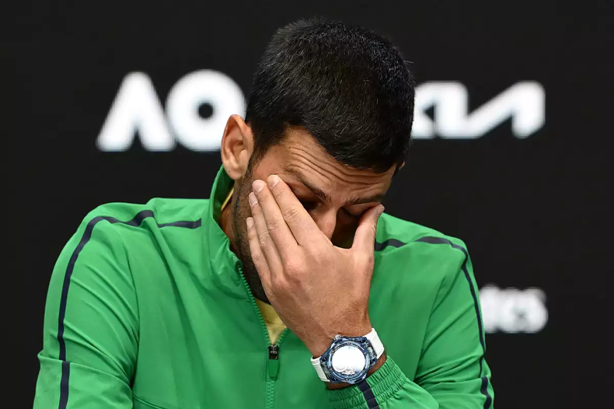 Foto de Novak Djokovic llevandose la mano al rostro en señal de cansancio