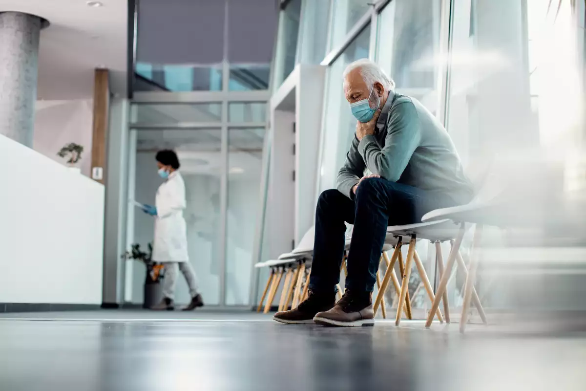 Un paciente espera consternado consulta médica en un hospital. 