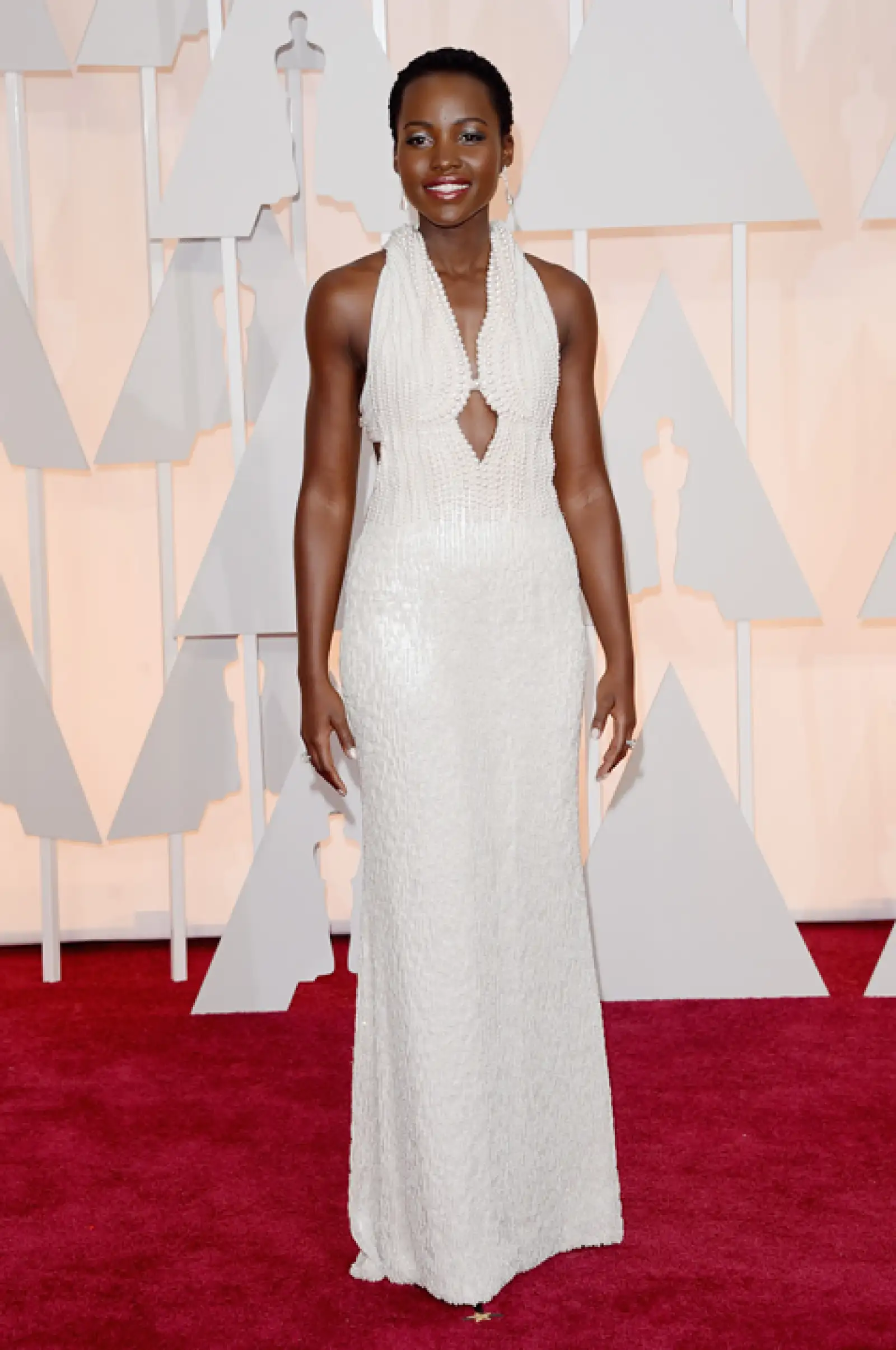 La actriz Lupita Nyongo lució espectacular con un vestido blanco de Calvin Klein. Para la fiesta de Vanity Fair usó un vestido ajustado dorado.