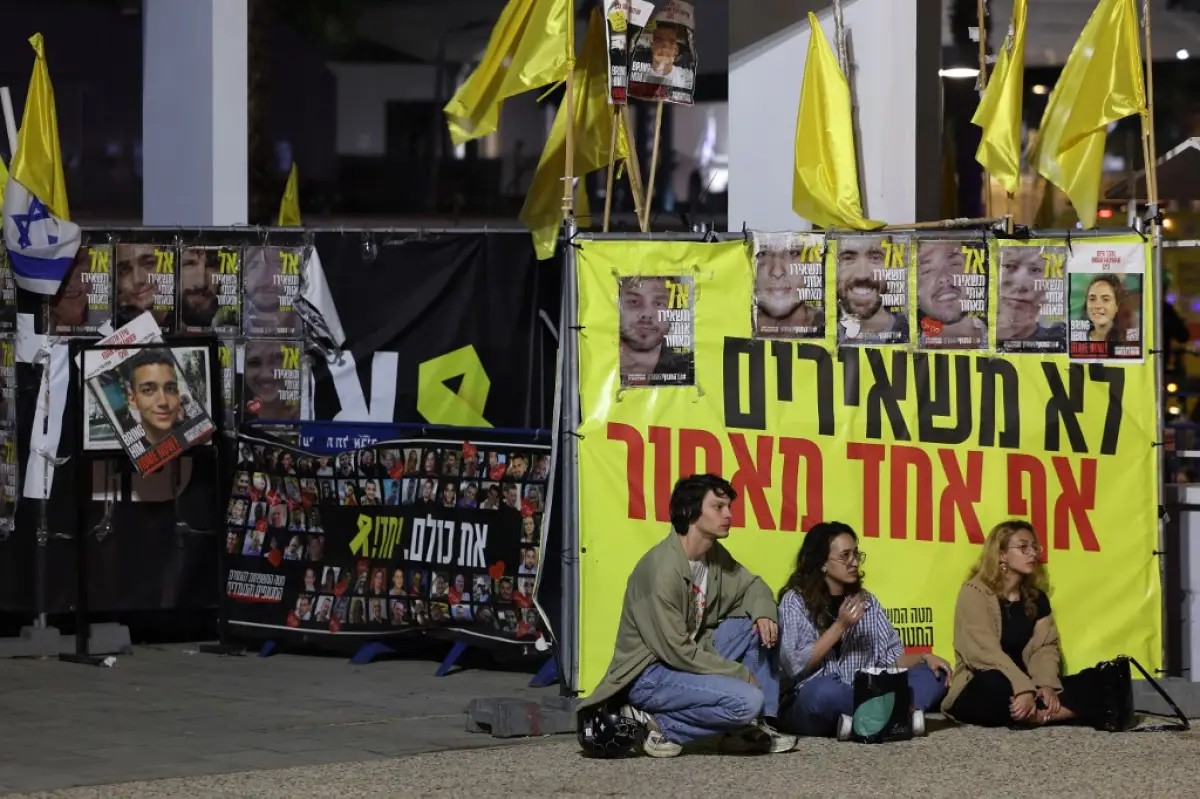 La gente guarda un minuto de silencio en el Día del Recuerdo del Holocausto, que conmemora a los seis millones de judíos asesinados en la Segunda Guerra Mundial, en la Plaza de los Rehenes en Tel Aviv el 23 de abril de 2025.