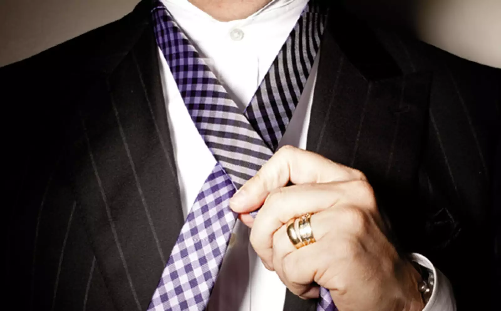 El extremo corto de la corbata debe estar a cinco botones y medio del cuello. Cruzar el extremo ancho sobre el delgado.